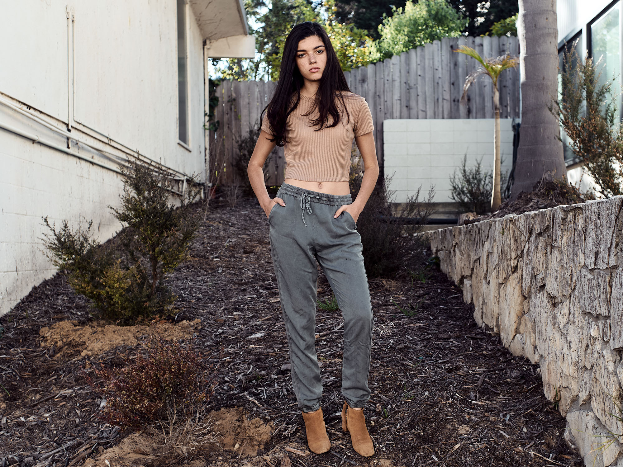 Casual digital portfolio image of a young model standing between buildings in Pacific Palisades, California