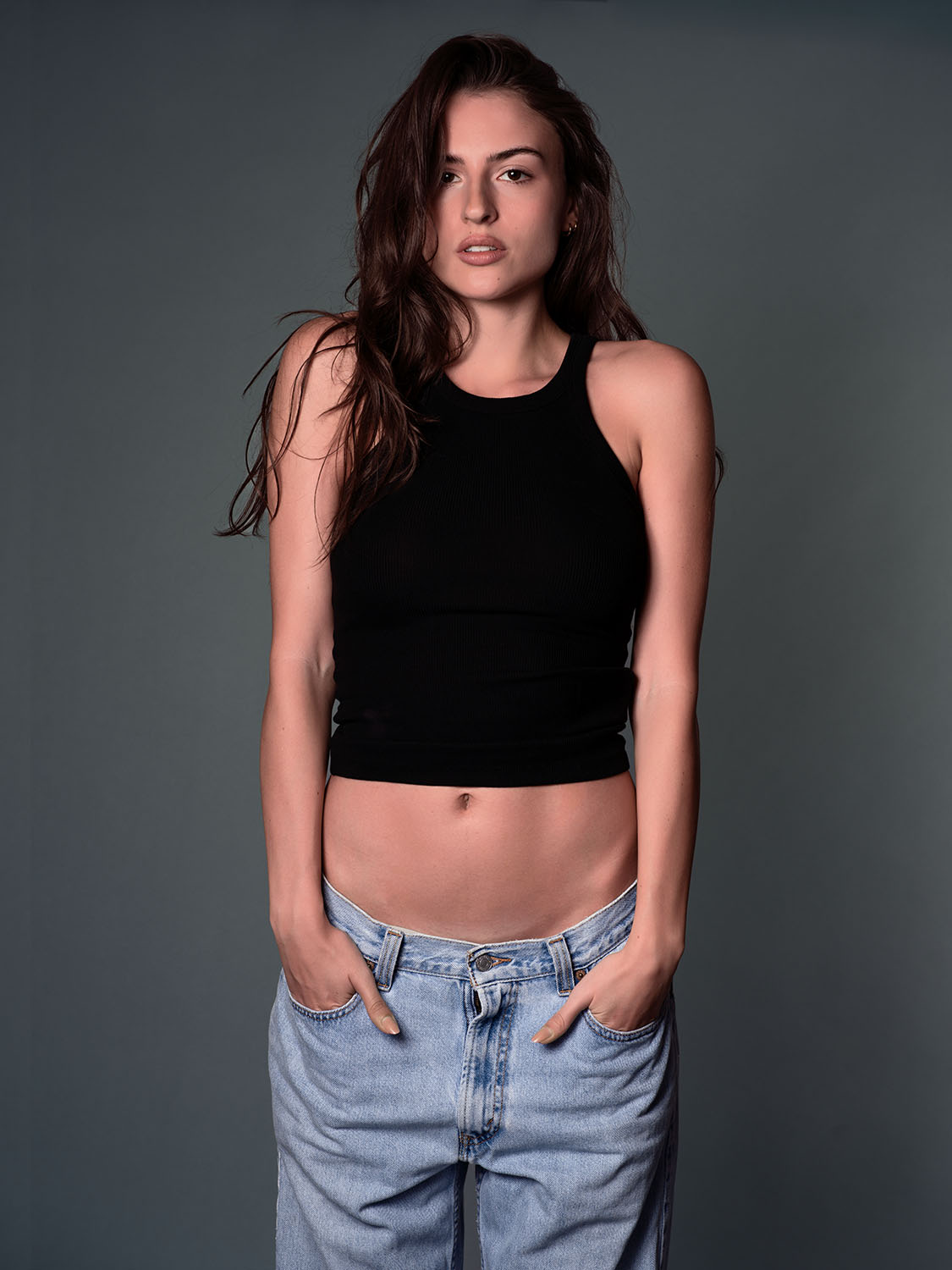 Studio portrait of Leah Morris from Willow Model Management Los Angeles, building her model portfolio in a black tank top and light denim jeans, confident and natural pose