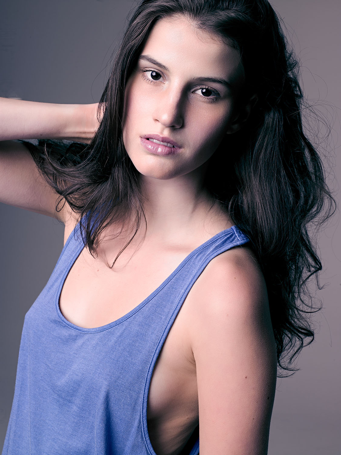 Comp card image of MC2 model Liz Kelley with natural makeup, soft expression, and studio lighting, wearing a blue tank top for portfolio